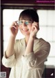 A woman wearing glasses and smiling at the camera.