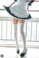 A woman in a maid outfit is posing for a picture.