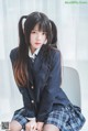 A young woman in a school uniform sitting on a chair.