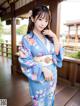 A woman in a blue kimono posing for a picture.